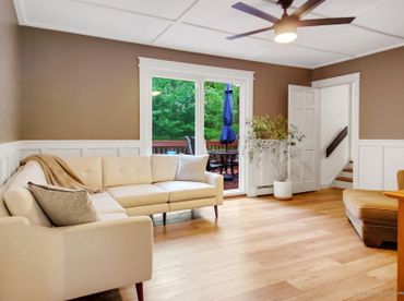 Bright living room with beige sectional sofa and sliding glass door to patio.