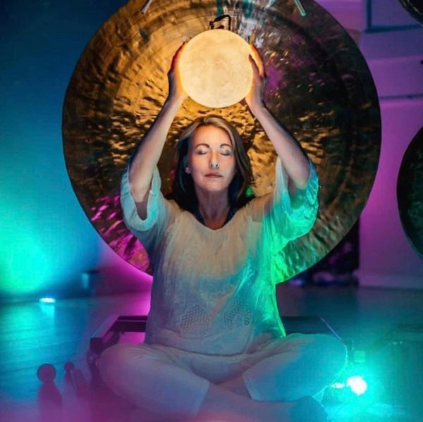A woman holding a moon lamp over the head