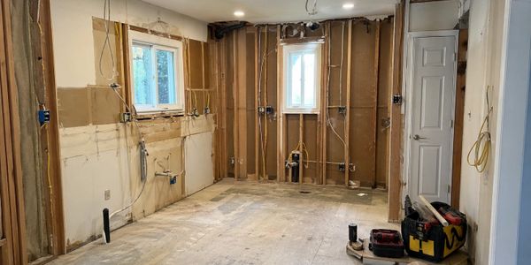 Room under renovation with exposed studs and wiring.