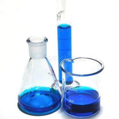 Laboratory glassware with blue liquid on white background.