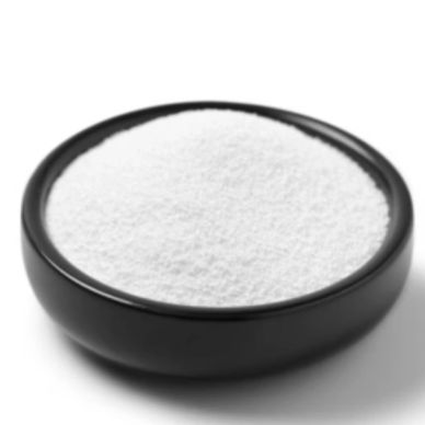 Black bowl filled with fine white powder on white background.