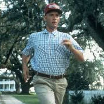Man running outdoors in a checkered shirt and red cap.