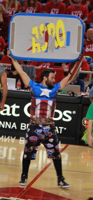 Man dressed as Captain America holding a sign upside down.
