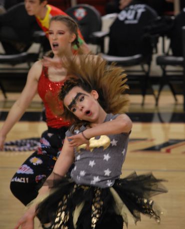 Girl dancing energetically with dramatic hair toss.