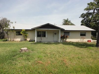 Single-story house with a large front yard and minimal landscaping.