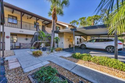 Apartment complex with carport and palm trees.