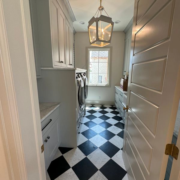 Laundry room with black and white checkered floor.