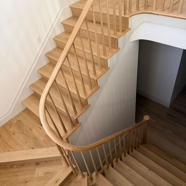 Wooden staircase with curved handrail.
