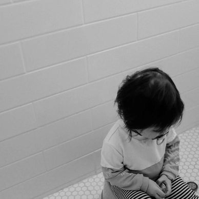Child sat on potty, a grey photo