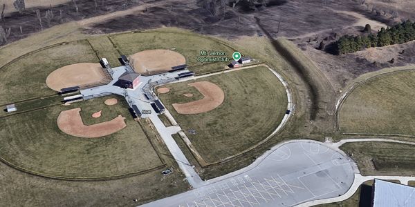 Aerial view of four baseball fields arranged around a central building.