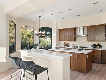 Modern kitchen with wooden cabinets and breakfast bar seating.