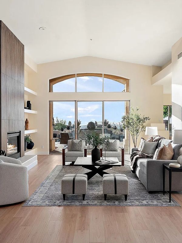 Bright modern living room with large windows and stylish furniture.