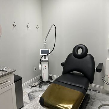 Modern clinic room with black reclining chair.