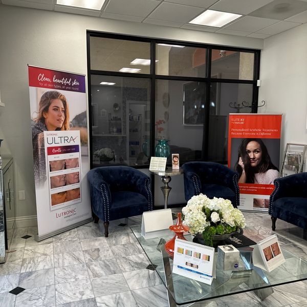 Cozy waiting area with blue chairs and skincare banners.