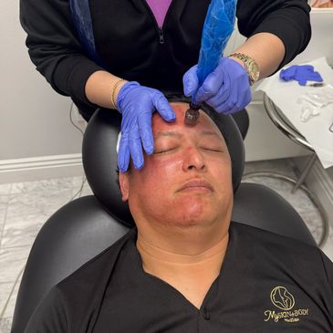 Man receiving a facial treatment with a device.