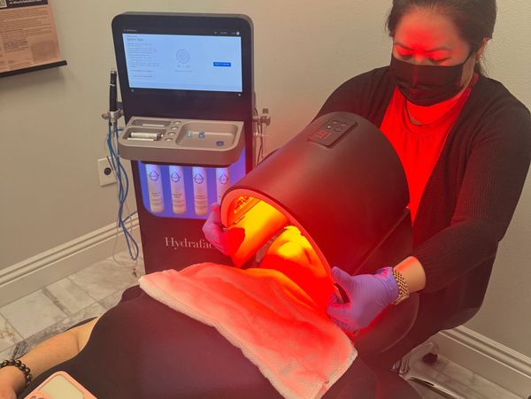Person receiving a red light facial treatment.