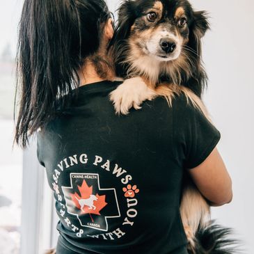 Person holding a dog, wearing a dog rescue t-shirt.
