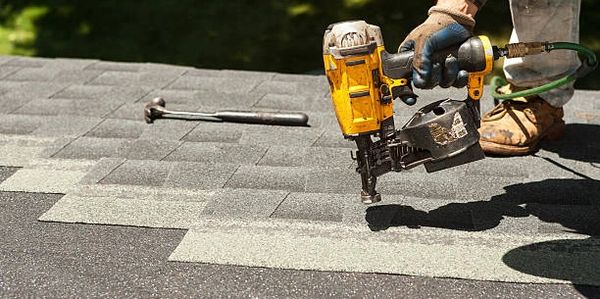 Roofer using tools to repair a roof.