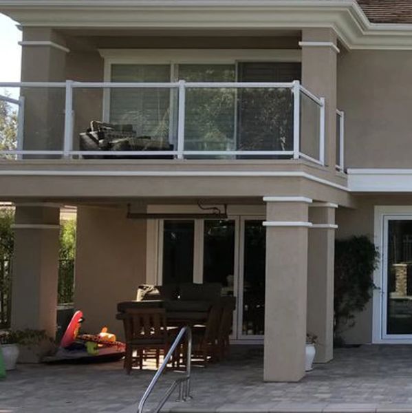 Painted residential balcony overlooking a stone patio.