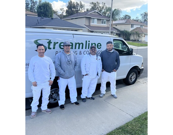 Four painters standing in front of service van.