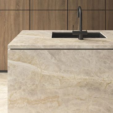 Modern kitchen island with marble finish and black faucet.