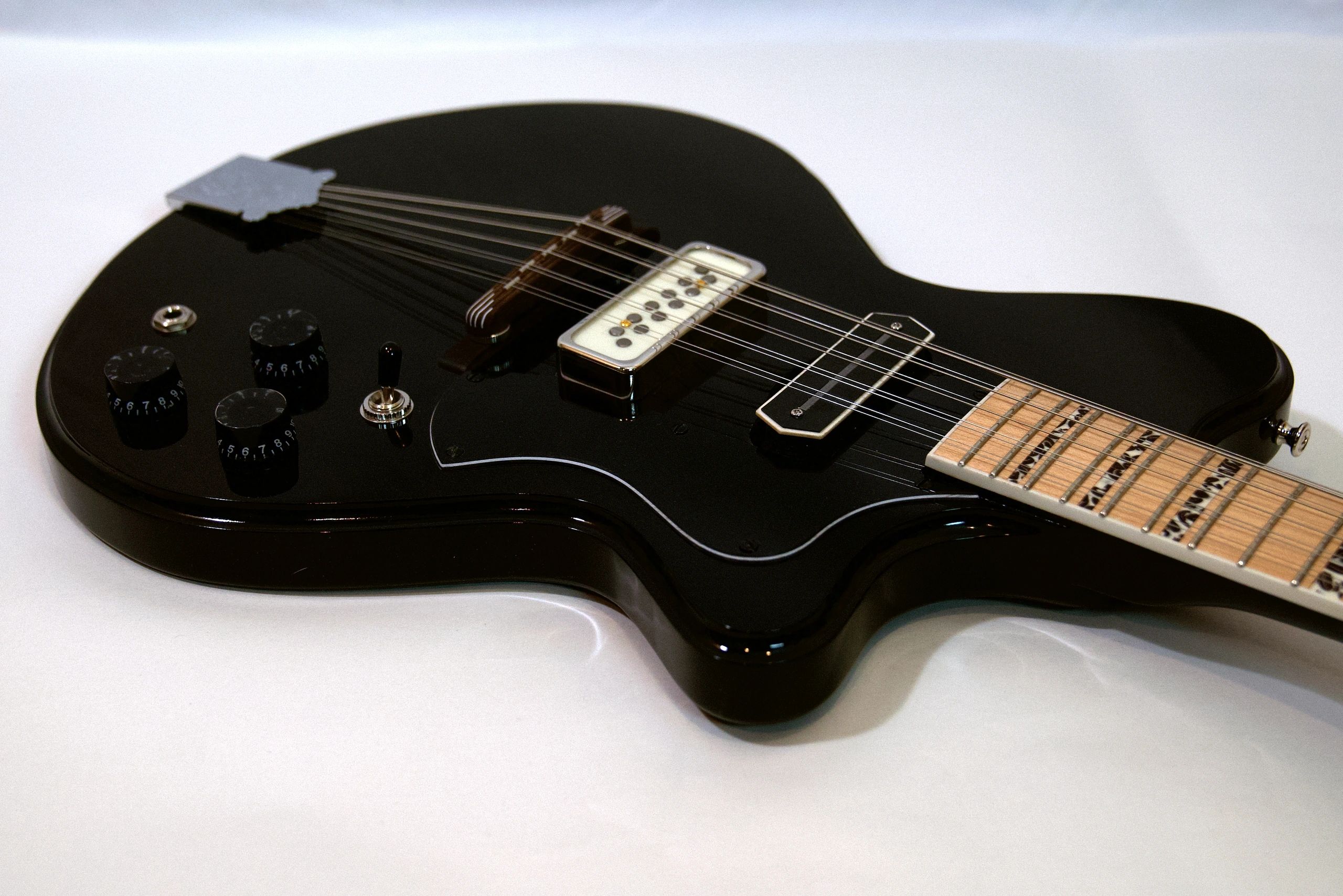 Close-up of a black electric guitar body.