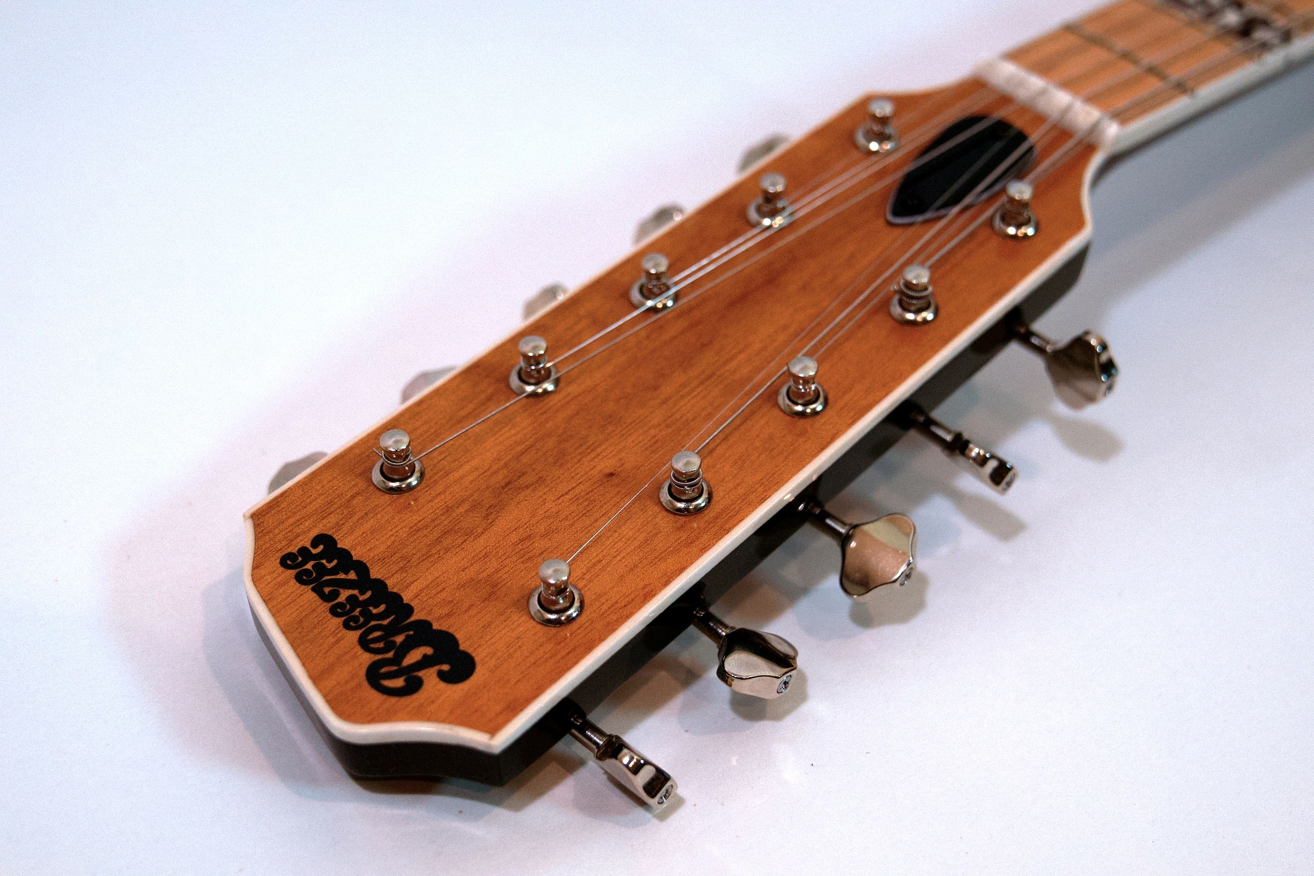 Close-up of a guitar headstock showing tuning pegs and strings.