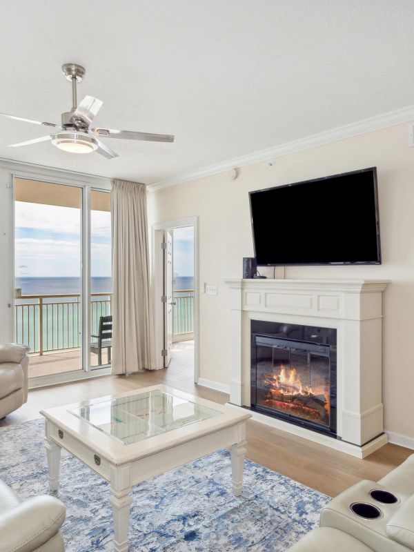 Bright living room with ocean view, fireplace, and TV.