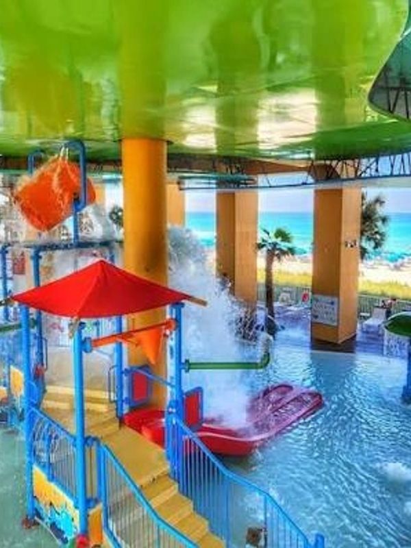 Colorful indoor water park with slides and splash features.