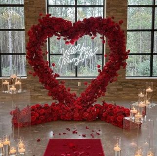 red flower heart shaped arch, red carpet, candles, proposal, wedding proposals