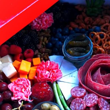 Colorful charcuterie board with meats, cheeses, and fruits.