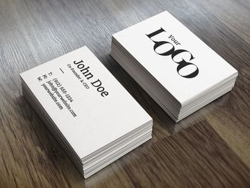 Stack of business cards on a wooden surface.