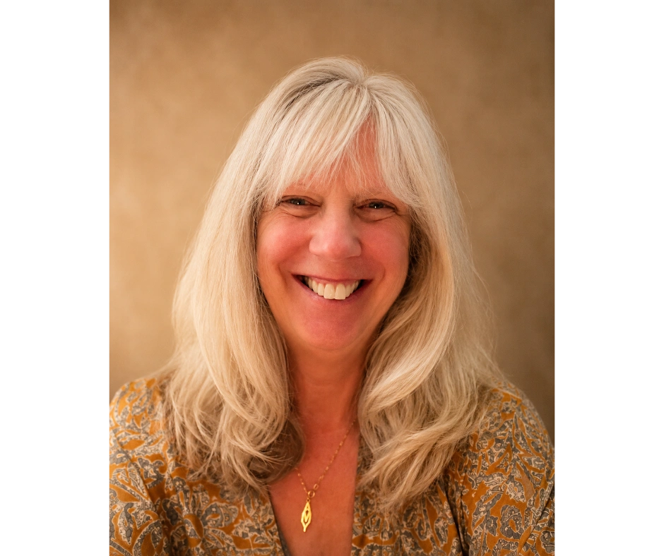 Smiling woman with glasses in blue top framed by a golden circle.