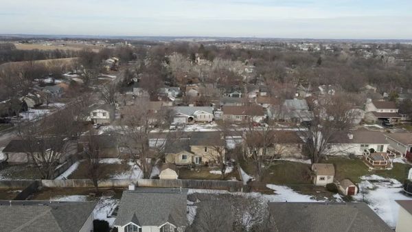 A suburban neighborhood with houses and bare trees in winter.