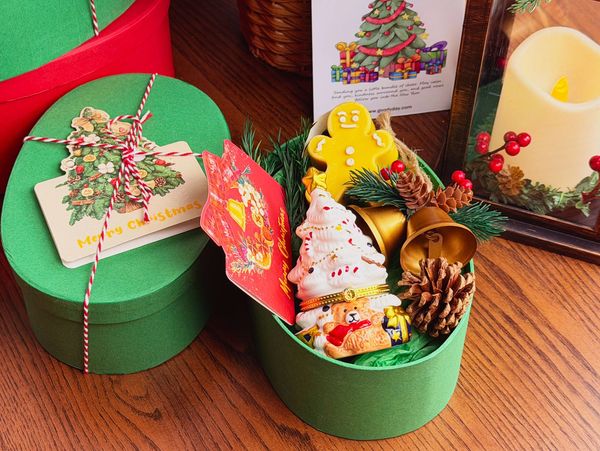 Christmas candle gift box with ceramic jar, holiday candle, bell ornament, pinecones and card.