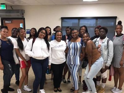 *All smiles!*Mentor and founder Kama with older girl's club group members, in classroom. 