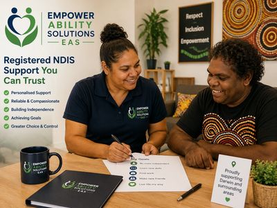 Two people smiling while discussing personalized NDIS support goals.