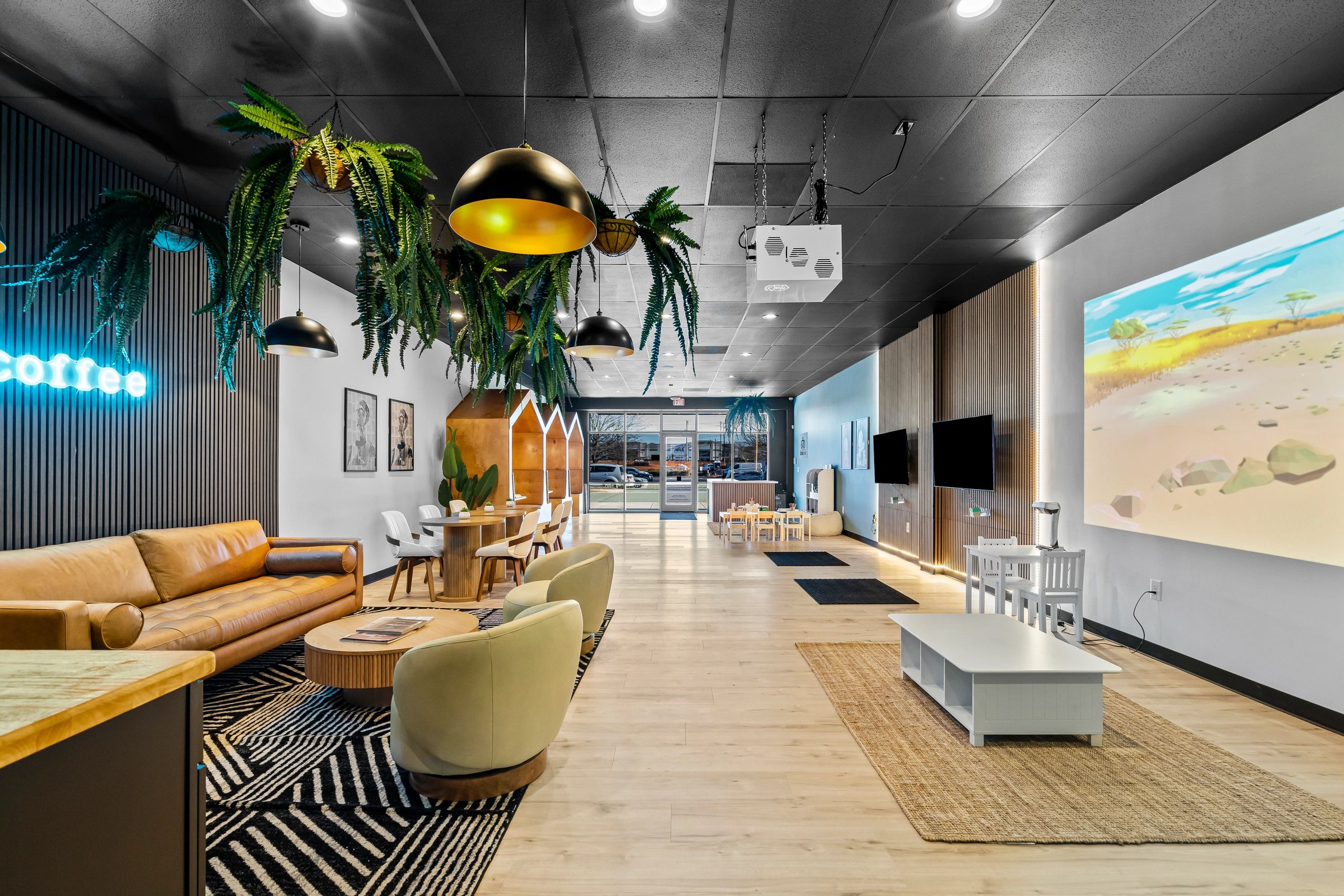 Modern coffee shop interior with hanging plants and cozy seating.