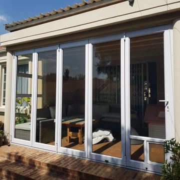 White aluminium stack away folding door with doggy door.