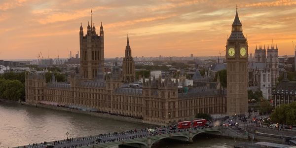 London's Houses of Parliament and Big Ben at sunset with Westminster Bridge.