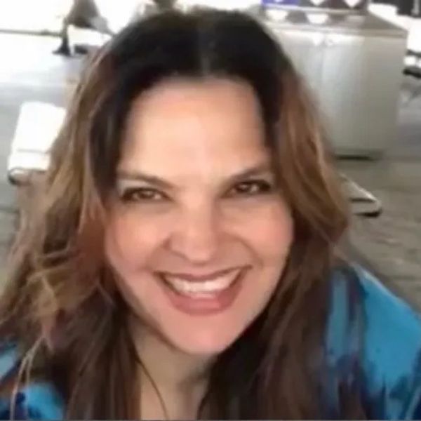 A woman with long hair smiling warmly at the camera.