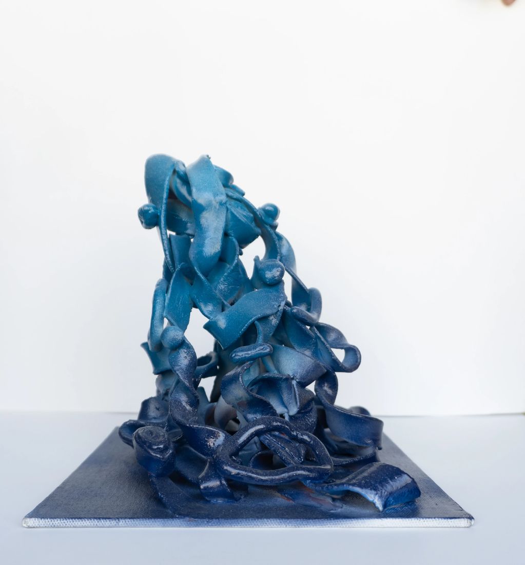 Abstract blue sculpture with swirling ribbon-like elements.