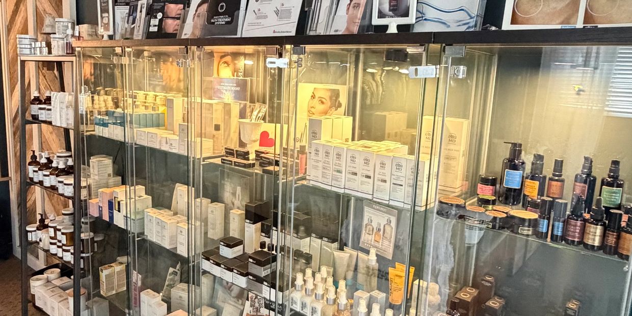 Glass display case filled with skincare products and bottles in a store.