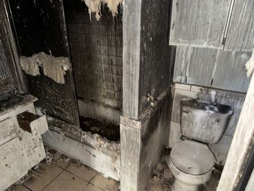 Bathroom severely damaged by fire and smoke.