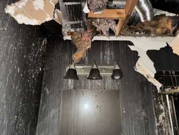 Bathroom ceiling and walls damaged by fire and smoke.