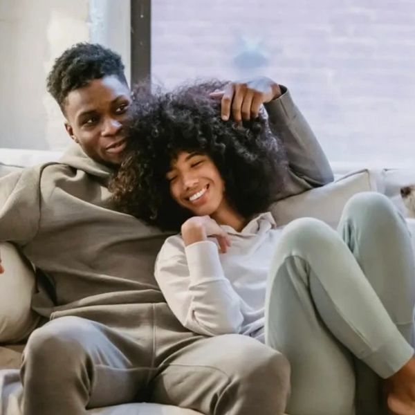 A happy smiling couple sitting comfortably in a restful embrace 