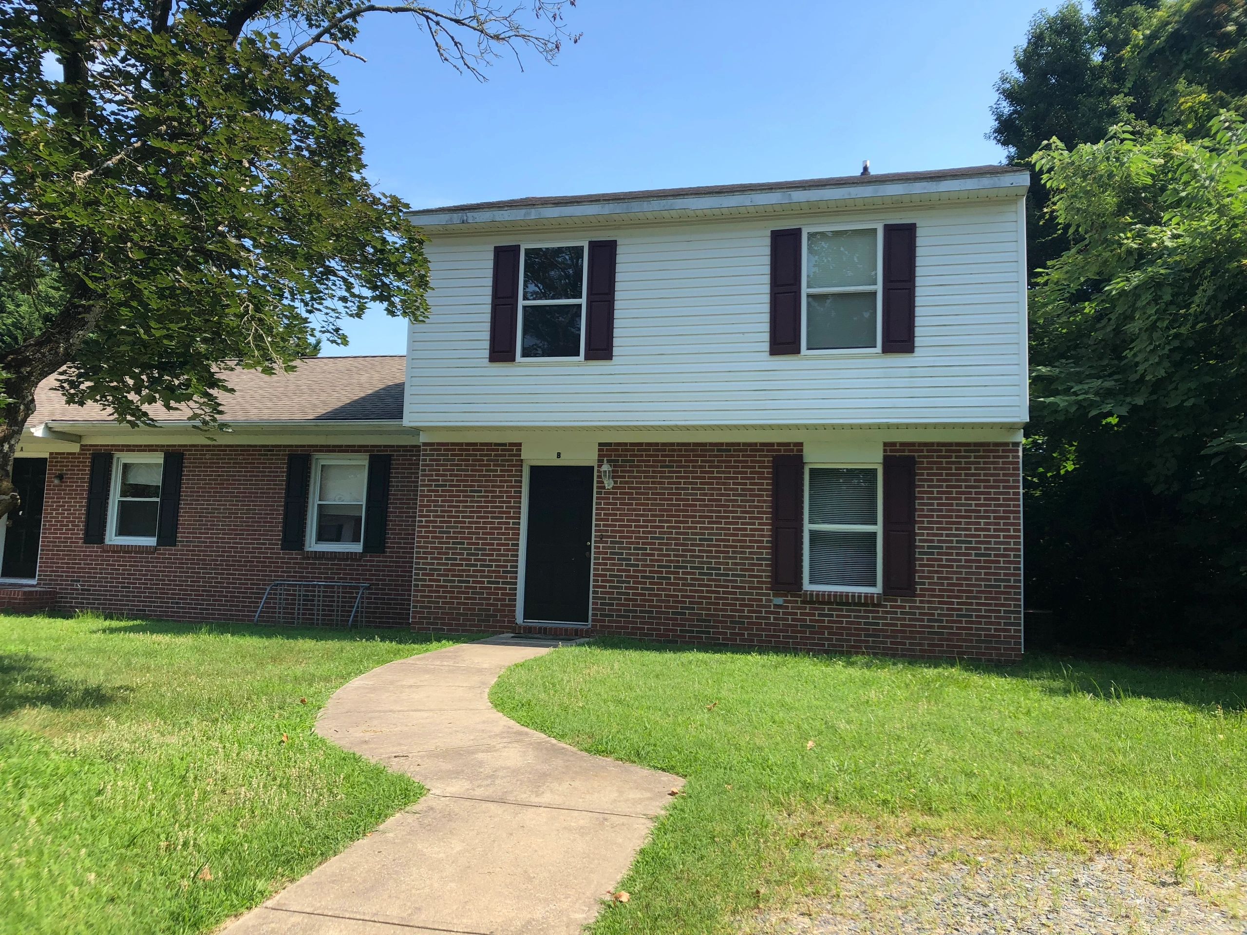 Two-story house with brick and white siding exterior.