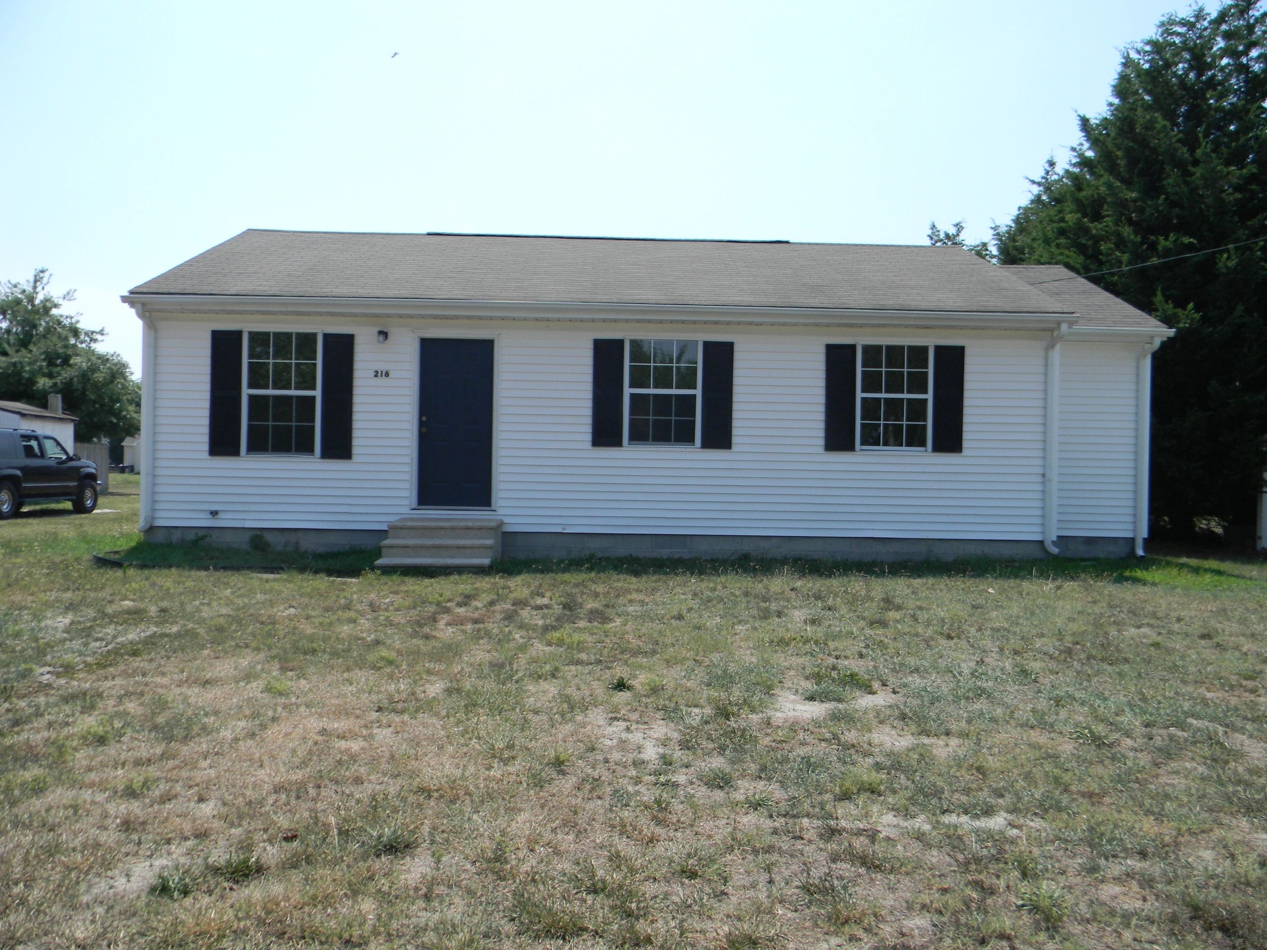 Small white house with blue door and black shutters.