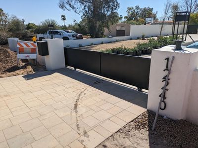 A modern driveway gate with house number 12340.