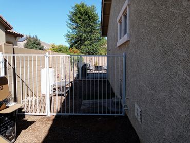 Side yard dog run with dual matching gates and open-view fencing. Peoria, Arizona.